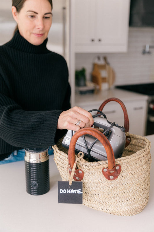 A woman placing items into a donate bin 